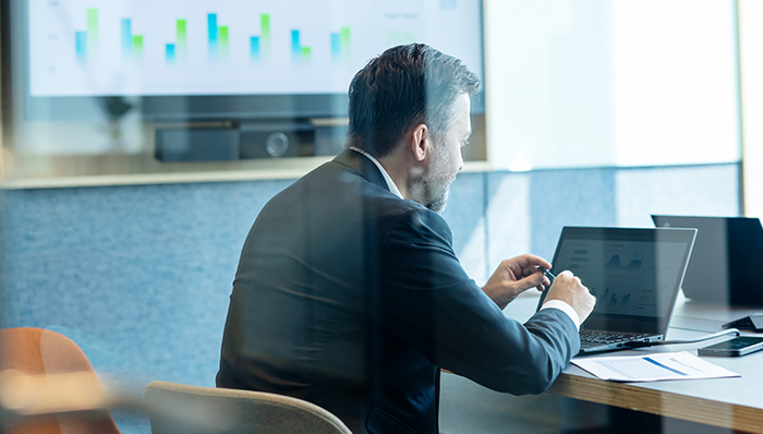 A man working on a laptop with charts